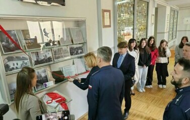 Zaproszeni goście odsłaniają pamiątkową gablotę poświęconą J&oacute;zefowi Jaroniowi, kierownikowi Publicznej Szkoły Powszechnej nr 2 w Staszowie w latach 1929-1939