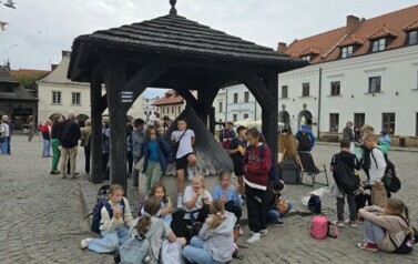 Uczestnicy wycieczki  przy studni na kazimierskim rynku