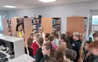 Grupa dzieci ogląda miejsce przeznaczone do wypożyczania książek