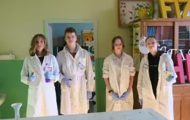 Uczniowie w białych fartuchach