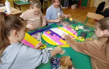 Cztery dziewczynki przyklejają kolorową bibułę