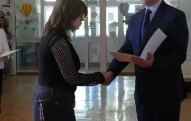 Zofia Krakowiak odbiera gratulacje z rąk dyrektora