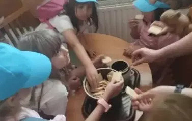 Kosztowanie miodu przez uczni&oacute;w klasy pierwszej