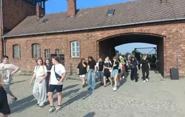 &Oacute;smoklasiści wraz z opiekunami wchodzący na teren obozu Birkenau