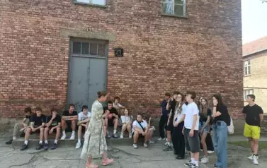 Uczniowie wraz z przewodniczką przed Blokiem 21 na terenie obozu