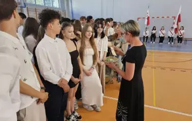 Wychowawczyni 8C rozdaje uczniom koniczynki wydrukowane na drukarce 3D