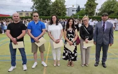 Grupa rodzic&oacute;w z dyrektorem stoją na środku