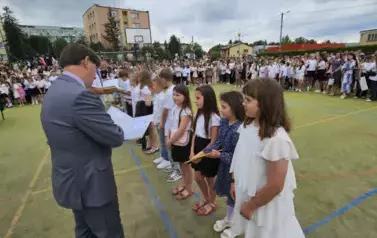 Grupa wyr&oacute;żnionych uczni&oacute;w klasy trzeciej otrzymuje nagrody