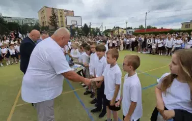 Grupa wyr&oacute;żnionych uczni&oacute;w klasy trzeciej otrzymuje nagrody