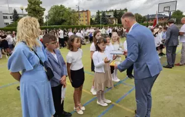 Grupa wyr&oacute;żnionych uczni&oacute;w klasy trzeciej otrzymuje nagrody