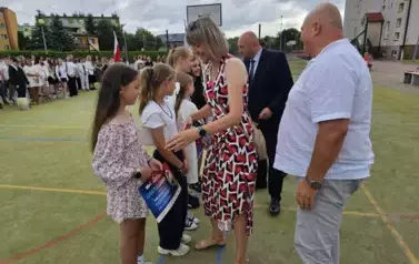 Radni i nauczyciel wręczają nagrody uczniom 