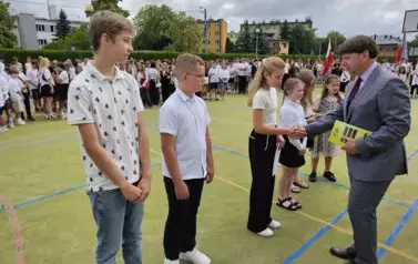 Dyrektor wręcza nagrody uczniom klas młodszych