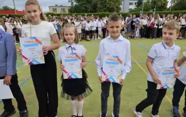 Grupa uczni&oacute;w klas młodszych z dyplomami