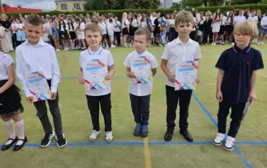 Grupa uczni&oacute;w klas młodszych z dyplomami