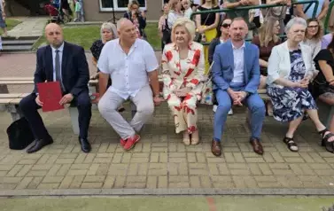 Zaproszeni goście siedzą na ławce