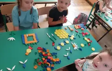 Trzy dziewczynki przy swoich pracach z klock&oacute;w