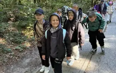 Grupa chłopc&oacute;w na leśnym szlaku