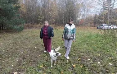 Dziewczynki spacerują po łące z pieskiem
