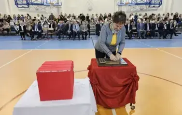 Dyrektor Biblioteki Publicznej w Staszowie Ewa Cygan podczas umieszczania symbolicznej tarczy na tabliczce pamiątkowej