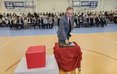 Dyrektor Banku Sp&oacute;łdzielczego Grzegorz Kozak  podczas umieszczania symbolicznej tarczy na tabliczce pamiątkowej