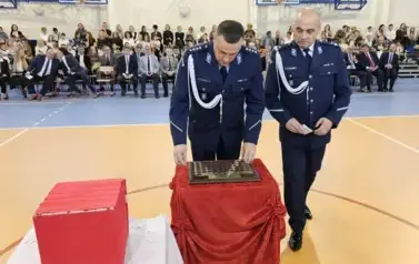 Przedstawiciele Komendy Policji w Staszowie podczas umieszczania symbolicznej tarczy na tabliczce pamiątkowej