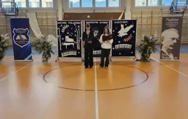 Uczniowie prowadzący uroczystość na środku sceny