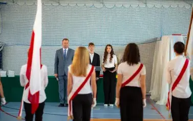 Wicedyrektor, uczniowie oraz poczet sztandarowy i flagowy podczas hymnu państwowego