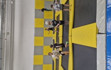 Grupa uczni&oacute;w na trampolinach