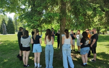Klasa 7C podczas czytania Zemsty zebrani wok&oacute;ł drzewa