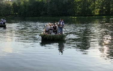 Uczniowie i flisacy na łodziach podczas spływu