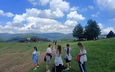Grupa uczennic klasy 4B na polanie podziwia widoki