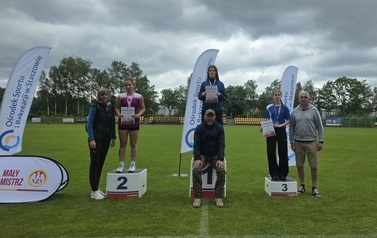 Nagrodzone dziewczęta na podium w biegu na 600 m wraz z nauczycielami