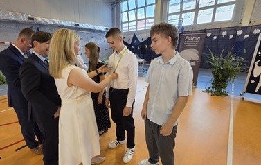 Nauczycielka Justyna Szczepańska, dyrektor Dariusz Kubalski i wicedyrektor Rafał Konat gratulują uczniom klasy 8 D za zajęcie I miejsca w og&oacute;lnopolskim turnieju Szkoła Przyjazna Energii
