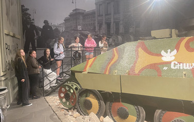 Uczniowie stojący przy czołgu w muzeum Wilczego Szańca