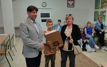 3Dyrektor szkoły, czwartoklasista trzymający laptop, matka chłopca
