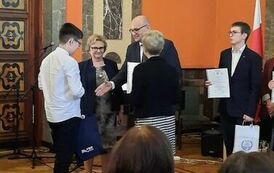 Wojciech Glica odbiera dyplom i nagrodę z rąk organizator&oacute;w Dyktanda