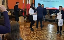 Julia Strojna odbiera dyplom i nagrodę z rąk organizator&oacute;w Dyktanda