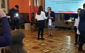 Julia Strojna odbiera dyplom i nagrodę z rąk organizator&oacute;w Dyktanda