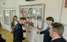Zaproszeni goście odsłaniają pamiątkową gablotę poświęconą J&oacute;zefowi Jaroniowi, kierownikowi Publicznej Szkoły Powszechnej nr 2 w Staszowie w latach 1929-1939