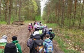 Grupa dzieci idzie leśną drogą