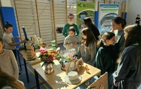 Uczniowie oglądają przedmioty z recyklingu