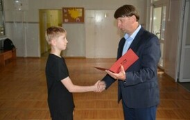Dyrektor Szkoły wręcza Szymonowi Myśliwcowi zaświadczenie o uzyskaniu tytułu finalisty konkursu z matematyki