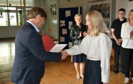 Dyrektor Szkoły wręcza Emilii Adamus zaświadczenie o uzyskaniu tytułu finalistki konkursu z chemii