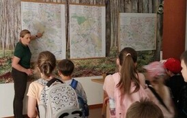 Grupa uczni&oacute;w słucha objaśnień pracownika nadleśnictwa