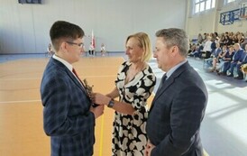 Burmistrz Miasta i Gminy Stasz&oacute;w dr Leszek Kopeć, zastępca burmistrza Miasta i Gminy Stasz&oacute;w dr Ewa Kondek wręczają Prymusowi Szkoły Wojciechowi Glicy statuetkę