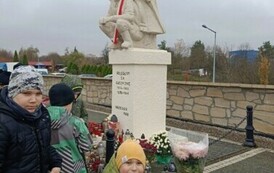 Uczniowie zapalają znicze przy pomniku Poległym za Ojczyznę