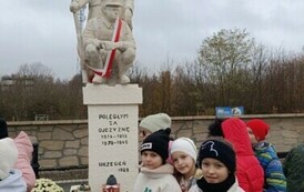 Uczniowie zapalają znicze przy pomniku Poległym za Ojczyznę