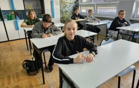 Uczniowie siedzący w ławkach podczas konkursu