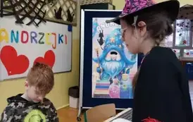 Chłopiec siedzący przy stoliku odczytuje wr&oacute;żbę