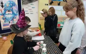 Dwie dziewczynki podczas wr&oacute;żby z kubk&oacute;w